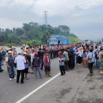Warga Tiga Desa Berusaha Memasuki Jalan Tol Cisumdawu, Tuntut Ganti Rugi Lahan JURNAL SUMA.COM., SUMEDANG - Warga tiga desa yang terdampak pembangunan Tol Cisumdawu, yakni Desa Sirnamulya, Mulyasari, dan Girimukti Kecamatan Sumedang Utara, Kabupaten Sumedang, Jawa Barat, kembali melakukan aksi demo menuntut pembayaran ganti rugi, Rabu (26/2). Aksi kali ini bahkan sempat diwarnai aksi saling dorong antara petugas keamanan gabungan dengan massa aksi yang terdiri dari kalangan orangtua, termasuk kaum ibu-ibu. Pantauan di lokasi, aksi demo di KM 178 Dusun Binong Desa Sirnamulya ini diawali dengan pembentangan spanduk tuntutan. Selanjutnya warga langsung berupaya masuk ke badan jalan tol. Namun aksi warga yang berupaya menutup total ruas tol arah Bandung tersebut langsung diadang barikade petugas gabungan dari TNI/Polri, serta Satpol PP. Sejumlah warga bahkan sempat berhasil menerobos hingga jalan tertutup total. Namun Petugas berhasil mendesak massa aksi kembali ke bahu jalan, hingga akhirnya unjuk rasa dilakukan di sana. Salah seorang warga Desa Mulyasari yang terdampak tol, Dede Rohana mengatakan, di desa tersebut tercatat sebanyak 19 rumah hingga area persawahan yang terdampak. Sehingga, warga meminta kepada pemerintah hingga pihak terkait lainnya agar bidang tersebut bisa dibebaskan. "Semuanya ada 19 rumah sama sawah yang kena dampak. Harapannya sih pengen dibebasin sama pemerintah soalnya rumahnya juga pada rusak, pengennya secepatnya dibebasin. Kalau area persawahan itu kena longsor jadi tidak bisa ditanam apa-apa lagi udah banyak batu. Kalau normal dalam setahun bisa tiga kali panen," ujar Dede. Ia mengungkapkan, untuk pembebasan lahan sudah pernah ada pembahasan pada tahun lalu. Dalam pembahasan tersebut pihak terkait berjanji akan melakukan penetapan lokasi. Namun, hingga saat ini warga tidak mendapatkan kejelasan apapun terkait dengan tindak lanjut pembebasan lahan yang terdampak pembangunan. "Pernah ada pertemuan sama pihak terkait sama warga di tiga desa ini waktu di Desa Licin. Nah katanya dua Minggu setelah lebaran tahun kemarin ada penlok (penetapan lokasi) katanya dari beberapa bidang, tapi sampai sekarang tidak ada kabar lagi," tambah Dede. Disampaikan Dede, warga khususnya di tiga desa melakukan aksi demo karena mengaku sudah muak dengan tanpa adanya kejelasan soal pembebasan lahan ini maupun ganti rugi. "Iya sudah muak, soalnya demo bukan sekali dua kali, setiap demo ada BPN dama CKJT juga sama dari pemerintah cuman ya sampai dengan sekarang nggak jelas," imbuhnya. Aksi warga yang dilakukan sejak pagi hari tersebut akhirnya direspon oleh pihak terkait. Perwakilan dari CKJT serta PPK lahan Tol Cisumdawu pun tampak menemui massa unjuk rasa. Penanggungjawab lapangan PPK lahan Tol Cisumdawu, Wawan Eka Prasetya menyampaikan bahwa berlarut-larutnya proses pembebasan lahan di tiga desa tersebut lantaran kendala administrasi. "Kendala ini ada di administrasi, kendala berkas-berkas yang belum lengkap. Sebetulnya penlok sudah terbit pada dari gubernur tanggal 8 Mei 2024, sampai sekarang masih dalam proses permohonan pendelegasian dari BPN Kanwil. Untuk proses pendelegasian itu kami melengkapi berkas-berkas," kata Eka. Ia pun menjanjikan bahwa proses pelengkapan berkas akan dilakukan selambat-lambatnya minggu depan. "Dalam minggu ini kami akan melengkapi kekurangan tersebut. Setelah kami lengkapi kekurangan tersebut kami berharap surat pendelegasian bisa dilakukan ke BPN Sumedang," ucapnya. Sementara itu Kapolres Sumedang AKBP Joko Dwi Harsono memastikan bahwa meski warga melakukan unjuk rasa di jalan tol, namun arus lalu lintas tetap lancar. Menurut Kapolres, masyarakat berlaku kooperatif sehingga aksinya tidak mengganggu arus lalin Tol Cisumdawu. "Kami bersama TNI serta satuan pengamanan dari Pemda Sumedang memfasilitasi supaya warga melaksanakan niatnya berunjuk rasa menuntut haknya tapi juga tidak mengganggu ketertiban umum," imbuhnya. Usai melakukan unjuk rasa selama sekitar 4 jam, massa aksi kemudian membubarkan diri dengan tertib sekira pukul 12.10 WIB. Warga pun berharap aksi mereka kali ini diperhatikan oleh pemerintahan baru baik bupati, gubernur, hingga presiden, agar pembayaran ganti rugi segera terealisasi.