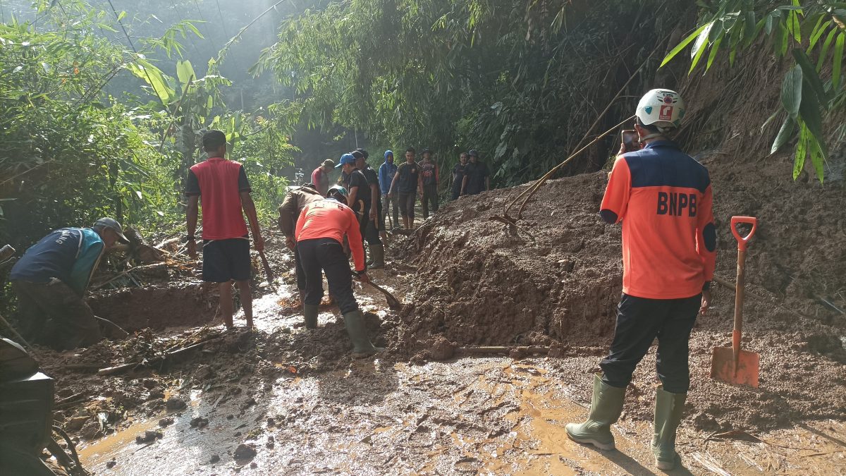 Pasca Longsor Petugas Bersihkan Material Tanah dengan Alat Seadanya